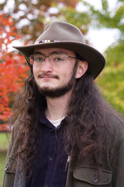 Juni, with their iconic cowboy hat and cordouroy shirt with pen in pocket